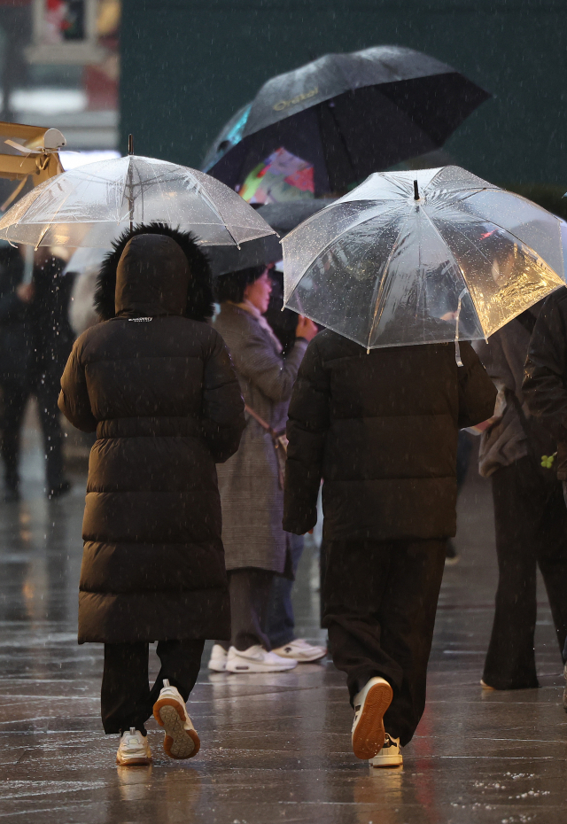 비가 내린 6일 오후 서울 중구 롯데백화점 본점 앞으로 패딩을 입은 시민들이 우산을 쓰고 걷고 있다. 연합뉴스