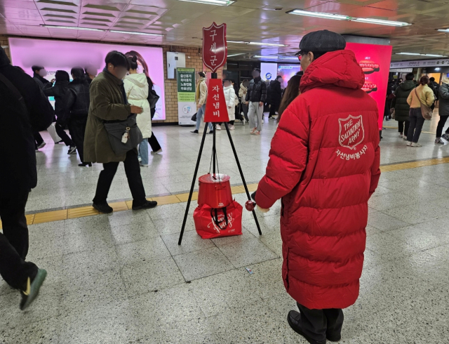 시민이 11일 오후 서울 지하철 2호선 건대입구역에 설치된 구세군 자선냄비에 현금을 기부하고 있다. 사진=정유민 기자
