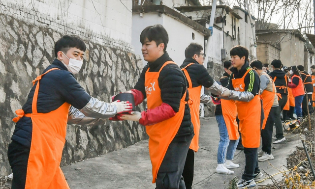 KT&G 임직원들이 지난 5일 서울 노원구 백사마을에서 ‘연탄나눔’ 봉사활동에 참여하고 있다. /사진제공=KT&G