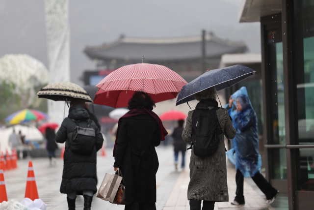 비가 내린 14일 오후 우산을 쓴 시민들이 서울 광화문광장을 지나고 있다. 연합뉴스