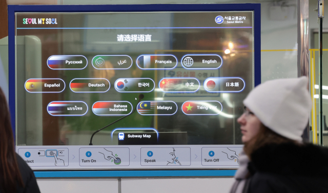4일 오후 서울 지하철 4호선 명동역에 투명한 유기발광다이오드(OLED) 디스플레이를 사이에 두고 외국인과 역 직원이 각각 자국어로 대화하는 외국어 동시 대화 시스템이 시범 운영되고 있다. 연합뉴스