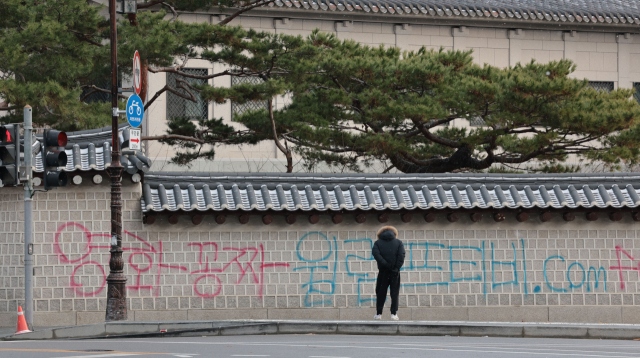 16일 오전 서울 종로구 국립고궁박물관 방향 경복궁 서쪽 담벼락에 붉은색과 푸른색 스프레이로 낙서가 적혀있다. 연합뉴스