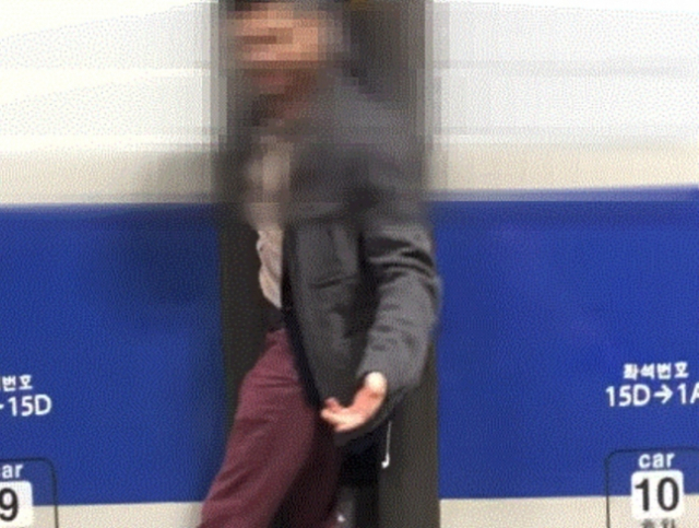한 외국인 남성이 경기 광명역에서 달리는 KTX에 매달린 채 항의하고 있다. 유튜브 영상 캡처