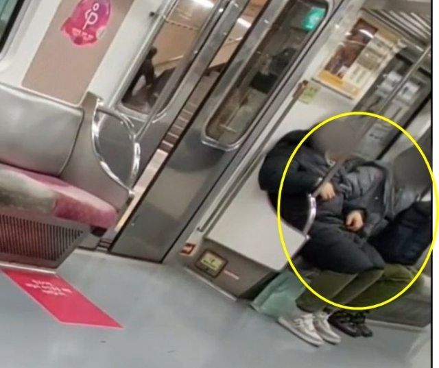 50대 남성이 지난달 30일 오후 11시43분께 지하철 5호선 방화역 방향으로 운행하는 전동차 내부에서 잠든 피해자의 주머니에 손을 집어넣어 휴대전화를 훔치고 있다. 사진 제공=서울경찰청 지하철경찰대