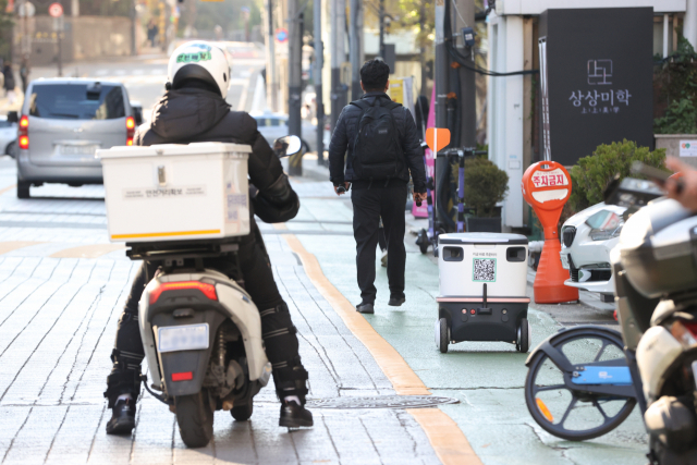 서울 강남구 테헤란로 일대에서 자율주행 배달로봇 '뉴비'와 배달기사가 도로를 오가고 있다. /연합뉴스