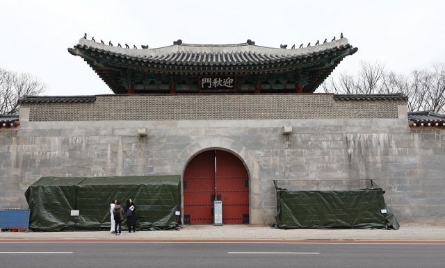 19일 오후 서울 종로구 경복궁 영추문에 지난 16일과 17일 낙서로 훼손된 담벼락 복구 작업을 위한 가림막이 설치돼 있다. 연합뉴스