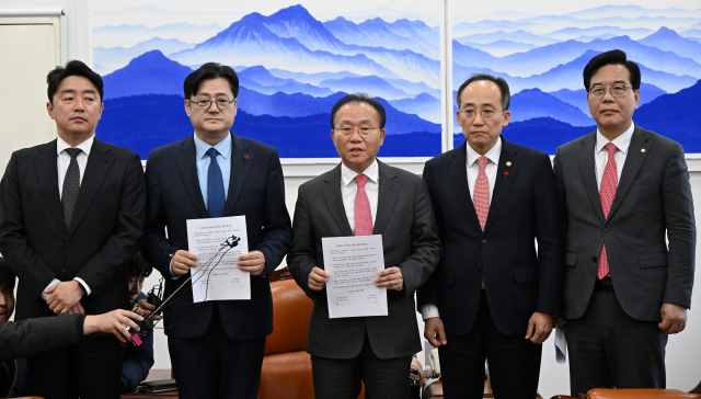 윤재옥(왼쪽 세 번째) 국민의힘 대표 권한대행 겸 원내대표와 홍익표(〃 두 번째) 더불어민주당 원내대표 등이 20일 오후 국회 운영위원장실에서 2024년도 예산에 대한 최종 합의문을 발표하고 있다. 강훈식(왼쪽부터) 민주당 예결위 간사, 홍 원내대표, 윤 권한대행, 추경호 부총리, 송언석 국민의힘 예결위 간사. 권욱 기자