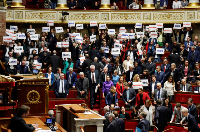 19일(현지 시간) 프랑스 상·하원을 통과한 이민법 개정안에 항의하는 좌파 선거연합정당 뉘프(Nupes·신사회생태인민연합) 의원들이 ‘자유’ ‘평등’ ‘박애’라고 적힌 팻말을 들고 항의하고 있다. AFP연합뉴스