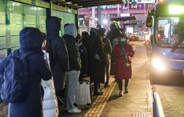 20일 오후 9시를 기해 서울 전역에 한파경보가 발효된 가운데 서울 중구 서울역 앞 버스환승센터에서 두꺼운 외투를 입은 시민들이 버스를 기다리고 있다. 연합뉴스