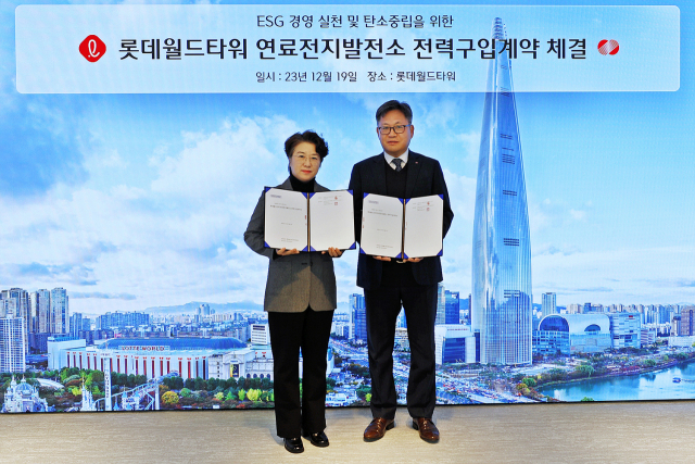 19일 서울 잠실 롯데월드타워에서 손유경(왼쪽) 롯데물산 기술안전부문장과 주화식 한국전력공사 강동송파지사장이 연료전지 전력 매매 계약을 체결하고 있다. 사진 제공=롯데물산