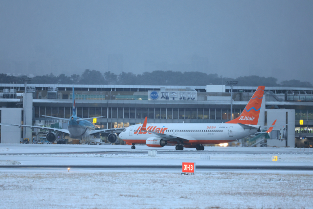 북극발 한파가 몰아친 21일 오후 제주국제공항 활주로에 눈이 쌓여 있다. 연합뉴스