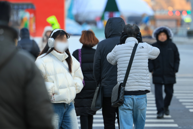 전국 대부분 지역에 한파특보가 발효된 22일 오전 서울 광화문네거리에서 한 시민이 귀를 손으로 덮으며 횡단보도를 건너고 있다. 연합뉴스