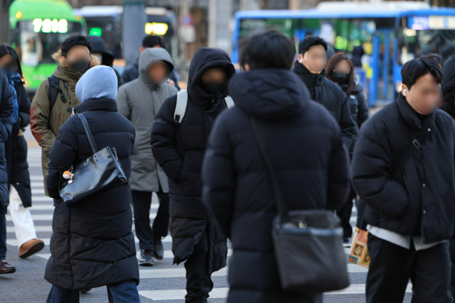전국 대부분 지역에 한파특보가 발효된 22일 오전 서울 광화문네거리에서 두꺼운 옷을 입은 시민들이 횡단보도를 건너고 있다. 연합뉴스