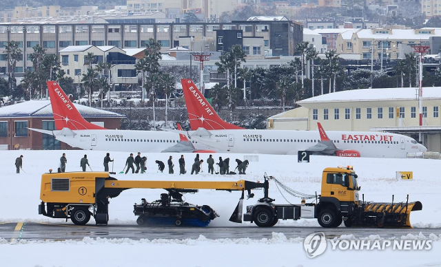 폭설이 내린 22일 오후 제주국제공항 활주로에서 해군 장병들이 제설작업을 하고 있다./사진=연합뉴스