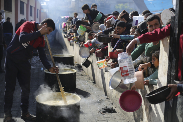 지난 20일(현지시간) 가자지구 남부 라파에서 팔레스타인인들이 무료 음식을 받기 위해 줄을 서고 있다. 연합뉴스