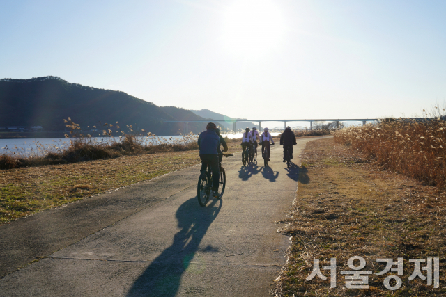 여행객들이 자전거를 타고 낙동강을 따라 영남대로 자전거길을 달리고 있다.