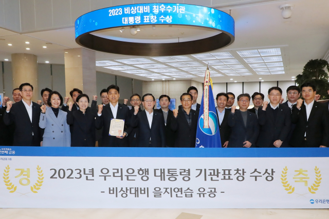 우리은행이 2023년 비상대비 을지연습 유공으로 대통령 기관표창을 수상해 조병규(앞줄 왼쪽에서 다섯 번째) 은행장과 임직원들이 28일 서울 중구 우리은행 본점에서 기념촬영을 하고 있다./사진 제공=우리은행