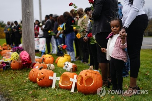 지난 10월 총기 난사 사건이 발생한 메인주 루이스턴의 한 볼링장 밖에서 사람들이 희생자들을 추모하며 기도하고 있다. 연합뉴스