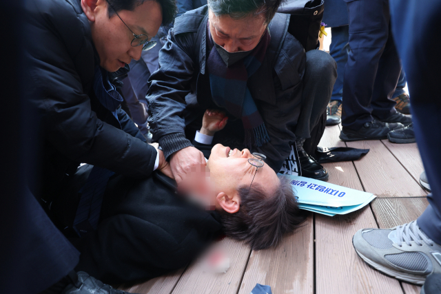 이재명 더불어민주당 대표가 2일 오전 부산 강서구 가덕신공항 부지를 둘러본 뒤 왼쪽 목 부위 피습을 당해 바닥에 누워 병원 호송을 기다리고 있다.연합뉴스