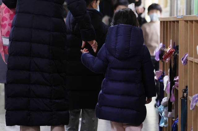 한 예비 초등학생이 지난해 예비소집에 참석해 엄마와 함께 교실을 둘러보고 있다. 연합뉴스