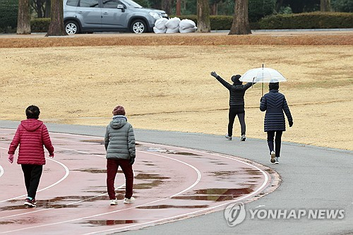 겨울비가 내린 3일 오전 광주 북구 전남대학교에서 시민이 산책하고 있다. 연합뉴스