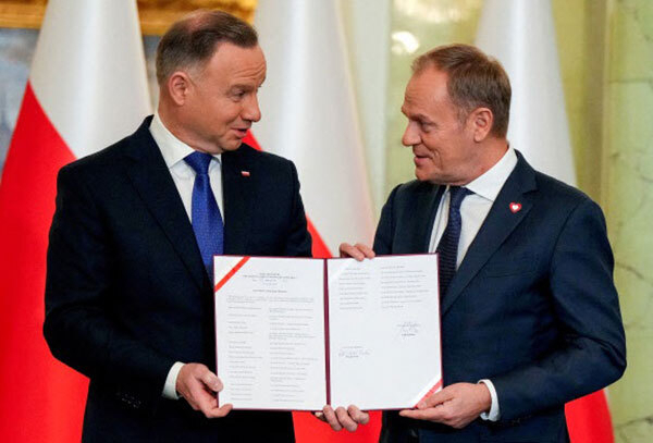 안제이 두다 폴란드 대통령(왼쪽)이 지난해 12월 13일(현지시간) 도날트 투스크 신임 총리에게 임명장을 수여하며 기념촬영을 하고 있다. 웃고 있지만 둘은 정치적 앙숙으로 알려져 있다. 로이터연합뉴스