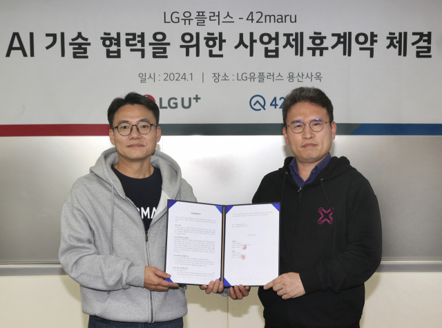 전병기(오른쪽) LG유플러스 AI·데이터기술그룹장과 김동환 포티투마루 대표가 LG유플러스 용산 사옥에서 업무협약을 맺은 후 협약서를 들어보이고 있다. 사진 제공=LG유플러스