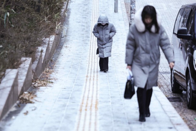 많은 눈이 예보된 9일 오전 서울 중구 을지로입구역 인근에서 시민들이 눈이 쌓인 오르막길을 걷고 있다.연합뉴스