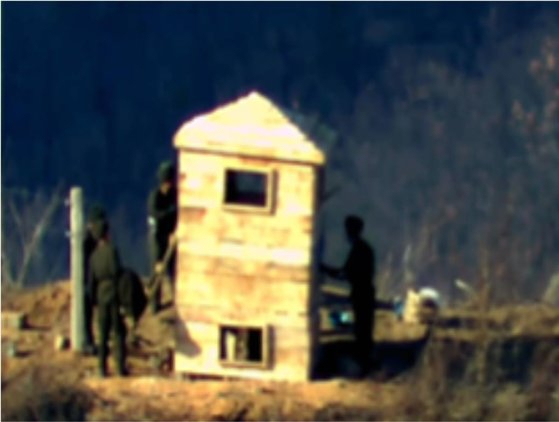 지난해 11월 24일 북한이 동부전선 최전방 소초(GP)에서 감시소를 복원하는 정황을 지상 촬영 장비와 열상감시장비(TOD) 등으로 포착됐다. 사진은 북한군이 목재로 구조물을 만들고 얼룩무늬로 도색하는 모습. 사진 제공=국방부