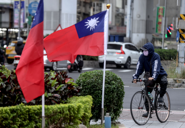 대만 타이베이시에서 한 시민이 자전거를 타고 대만 깃발 앞을 지나가고 있다. AFP연합