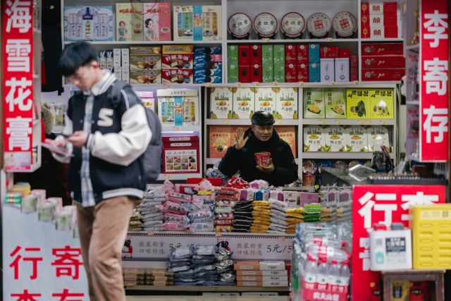 한 남성이 11일 중국 상하이의 식료품점 앞을 지나고 있다. 중국 경제는 소비 침체로 인해 2009년 이후 처음으로 3개월 연속 소비자물가지수(CPI)가 하락한 것으로 나타났다. EPA연합뉴스
