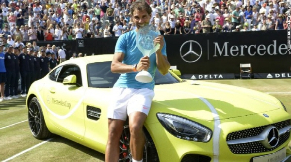 라파엘 나달이 2015년 ATP 투어 메르세데스컵에서 우승한 뒤 부상으로 받은 벤츠의 AMG GT차량 앞에서 우승 트로피를 깨물며 기념촬영을 하고 있다.