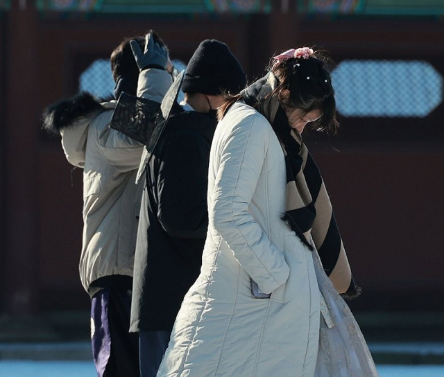 강추위가 찾아온 지난 7일 오전 서울 종로구 경복궁을 찾은 관광객들이 몸을 움츠린 채 길을 걷고 있다. 연합뉴스