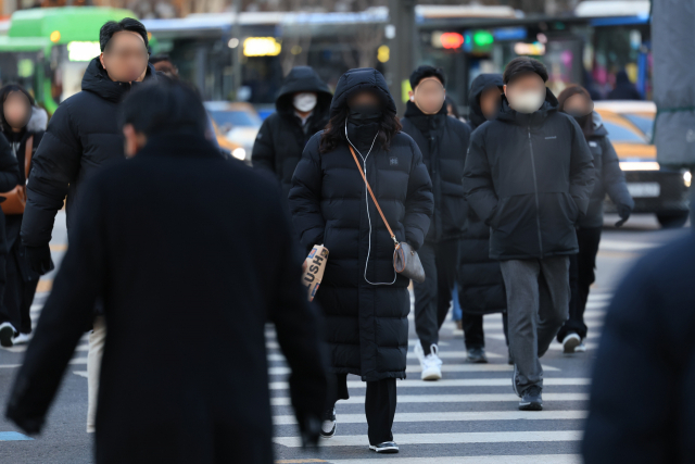 전국 대부분 지역에 한파특보가 발효된 지난달 22일 오전 서울 광화문네거리에서 두꺼운 옷을 입은 시민들이 횡단보도를 건너고 있다. 연합뉴스