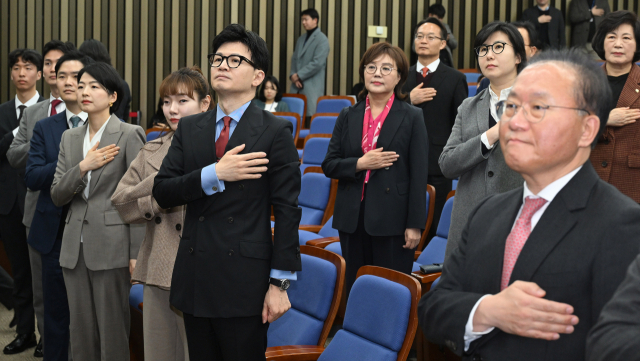 한동훈 국민의힘 비상대책위원장과 윤재옥 원내대표를 비롯한 의원들이 18일 서울 여의도 국회에서 열린 의원총회에서 국민의례를 하고 있다. 오승현 기자