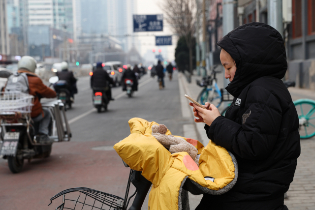 17일(현지 시간) 중국 베이징에서 한 여성이 출근을 하고 있다. EPA연합뉴스