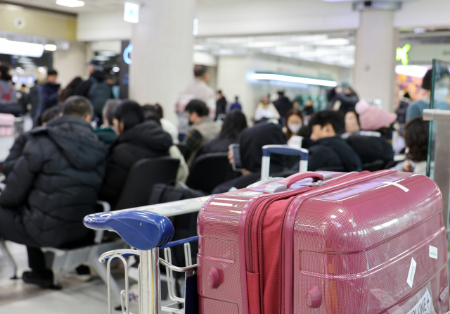 지난 23일 오전 제주국제공항 국내선 출발층에서 탑승객들이 지연되거나 결항된 항공편 운항 재개를 기다리고 있다. 연합뉴스