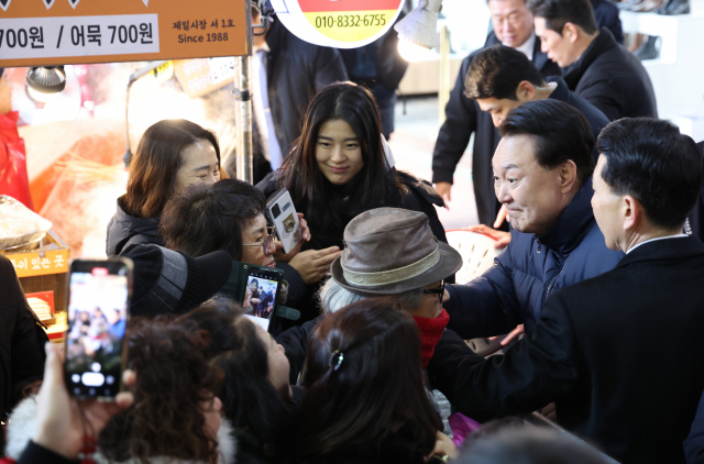 윤석열 대통령이 25일 경기도 의정부시 의정부제일시장을 찾아 시민들과 인사하고 있다. 의정부=연합뉴스