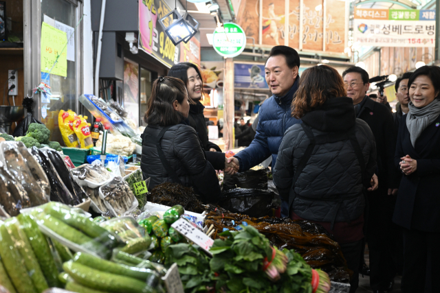 윤석열 대통령이 25일 경기도 의정부시 의정부제일시장을 찾아 상인들을 격려하고 있다. 연합뉴스