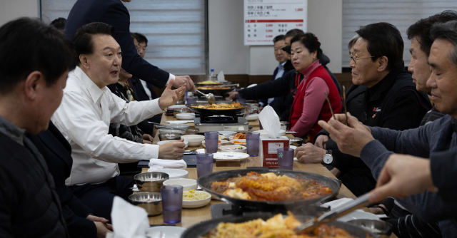 GTX-C 착공 기념식과 의정부제일시장을 방문한 윤석열 대통령이 25일 경기도 의정부시 한 부대찌개 식당에서 의정부 주민, 상인들과 점심 식사를 하고 있다. 연합뉴스