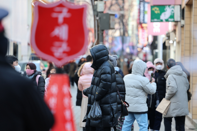 서울 명동 거리에서 외국인 관광객들이 방한용품으로 꽁꽁 싸맨 채 거리를 지나고 있다. 연합뉴스