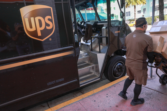 30일(현지 시간) 미국 플로리다주 마이애미 시내에서 한 UPS 배송기사가 고객들의 택배를 차량에서 옮기고 있다. UPS는 이날 글로벌 수요 부진에 대응해 관리직 1만2000명을 연내 감원할 계획이라고 발표했다. AFP연합뉴스