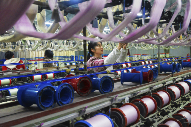 한 여성 노동자가 26일 중국 안후이성 위에시에 있는 비단 제직 공장에서 일하고 있다. AP연합