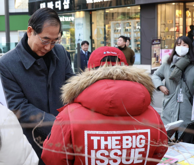 한덕수(왼쪽) 국무총리가 지난달 31일 서울 광화문역에서 빅이슈 판매원 곽창갑씨를 격려하고 있다. 한총리 페이스북 캡쳐