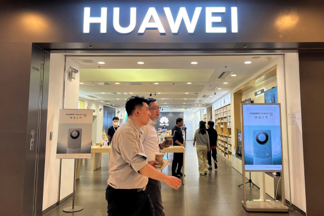 지난해 8월 30일(현지시간) 중국 베이징의 한 쇼핑몰에서 사람들이 화웨이 매장 내 ‘메이트60’ 스마트폰 광고판 앞을 지나가고 있다. 로이터연합뉴스