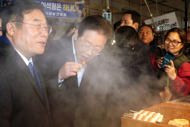 이재명 더불어민주당 대표가 5일 오후 광주 서구 양동시장에서 상인들과 만난 뒤 분식을 먹고 있다. 연합뉴스