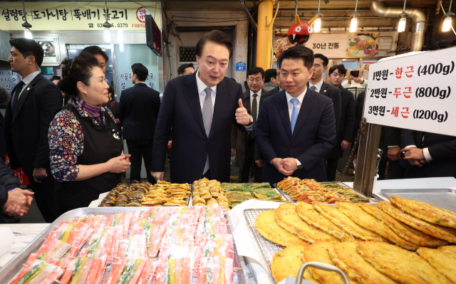 윤석열 대통령이 설 명절을 앞두고 8일 서울 광진구 중곡제일시장을 찾아 전 가게에서 박행복 사장(왼쪽) 등과 이야기를 나누고 있다. 연합뉴스