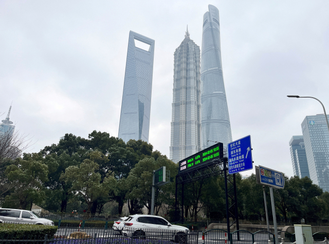 중국 상하이 금융가 도로 위에 표시된 주가지수 전광판 아래로 차량들이 지나고 있다. 로이터연합뉴스