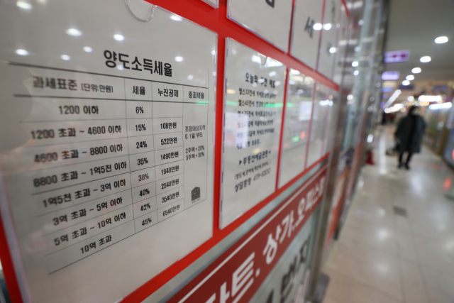 서울 강남소재 부동산중개업소 칸막이 창에 양도소득세율표가 붙어있다. /연합뉴스