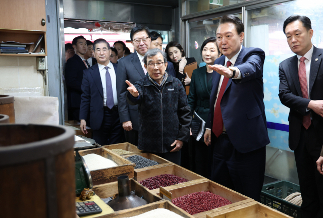 윤석열 대통령이 13일 부산 동래구 동래시장의 쌀가게를 방문해 상인과 대화하고 있다. 연합뉴스